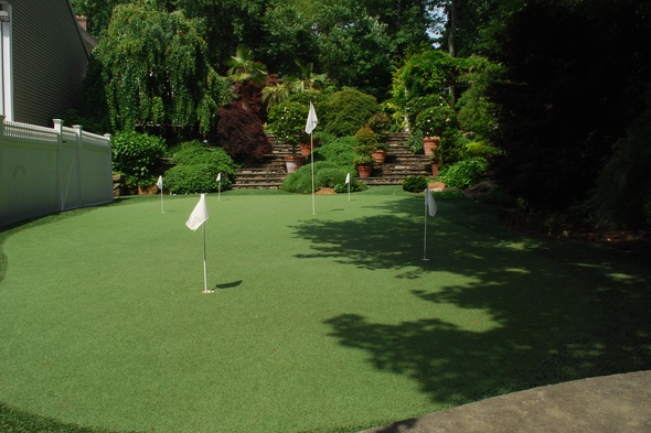 Kennewick Synthetic grass golf green with flags in a landscaped backyard