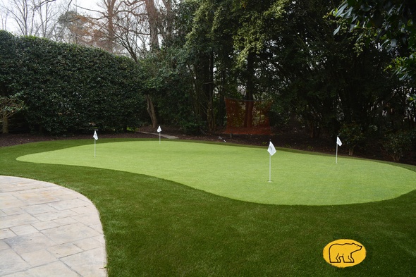 Kennewick Synthetic grass golf green with 4 holes and flags in a landscaped backyard