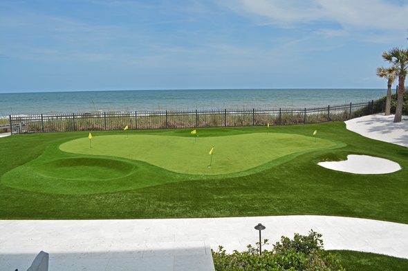 Kennewick Synthetic grass golf green by the sea with yellow flags and a sand bunker